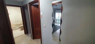 a view of a bathroom with a toilet and a mirror at Apartamentos Portolux in Portomarin