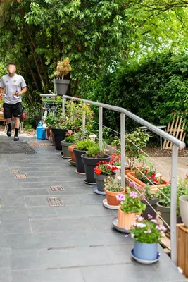 a man walking past a bunch of potted plants at Cruce de Caminos Arzúa in Arzúa