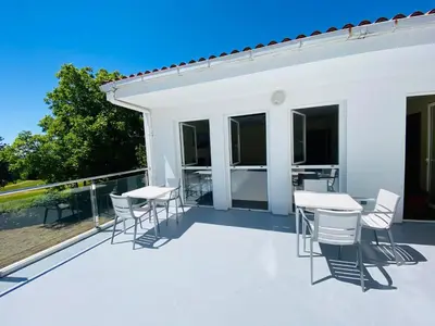 a patio with tables and chairs on a balcony at Cruce de Caminos Arzúa in Arzúa