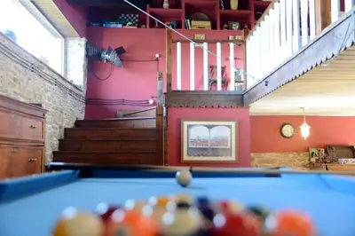 a pool table in a room with a staircase at Casa Rural Pico del Lugar in Villar de los Barrios