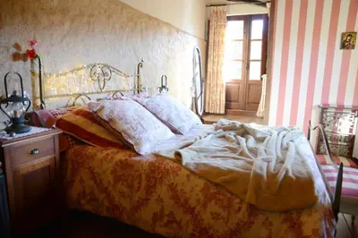 a bedroom with a bed with a blanket and pillows at Casa Rural Pico del Lugar in Villar de los Barrios
