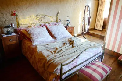 a bedroom with a large bed with a gold frame at Casa Rural Pico del Lugar in Villar de los Barrios
