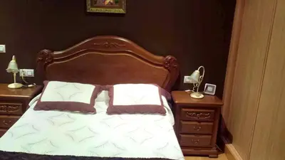 a bed with a wooden headboard and two night stands at Elegant House in Pontevedra + Private Pool in Rífrío