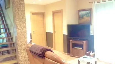 a living room with a couch and a flat screen tv at Elegant House in Pontevedra + Private Pool in Rífrío