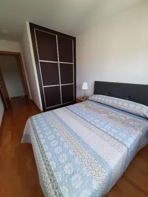 a bedroom with a bed with a blue comforter at Lugomar in Foz