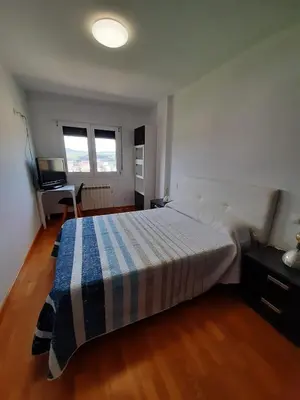 a bedroom with a bed with a blue and white blanket at Lugomar in Foz