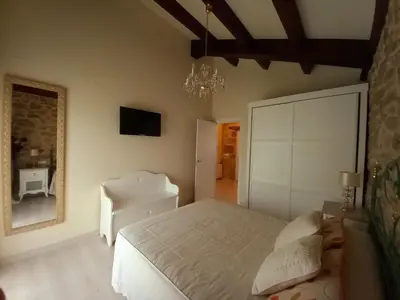 a bedroom with a white bed and a chair at Casa Xan in Jove