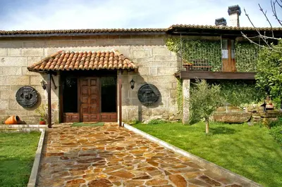 a stone house with a door and a yard at Casal de Drados in Drados