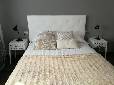 a bedroom with a large white bed with two lamps at Piso Camino De Santiago in Sarria