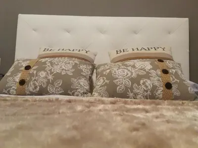 a bed with two pillows with the words be happy at Piso Camino De Santiago in Sarria