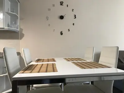 a table with chairs and a clock on the wall at Piso Camino De Santiago in Sarria
