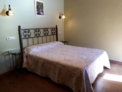 a bedroom with a bed with a pink bedspread at Apartamento El Valle de Oscos in Santa Eulalia de Oscos