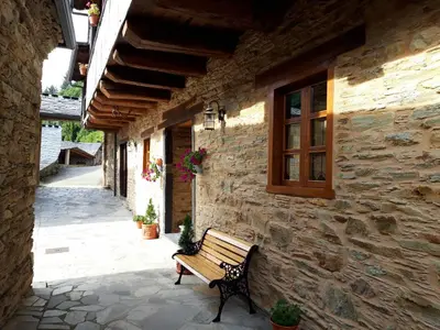 a bench sitting in front of a stone building at Apartamento El Valle de Oscos in Santa Eulalia de Oscos