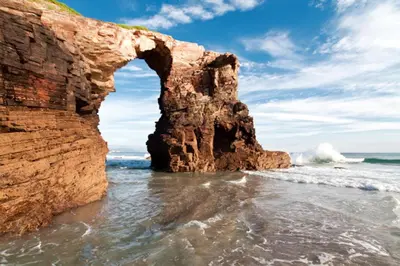an arch in a rock formation in the ocean at Stone Cottage O CEBREIRO in Curtis