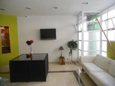 a living room with a couch and a tv on a wall at Albergue la Estacion Santiago de Compostela in Santiago de Compostela