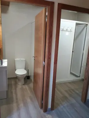 a bathroom with a toilet and a glass shower door at Albergue Pension Porta Santa in Baleira