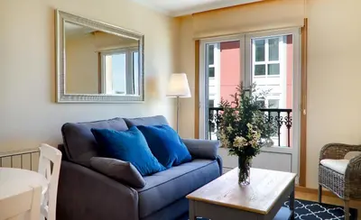 a living room with a blue couch and a table at Duerming Sea View Viveiro in Viveiro