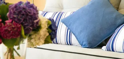 a couch with pillows and a vase of flowers on it at Duerming Sea View Viveiro in Viveiro