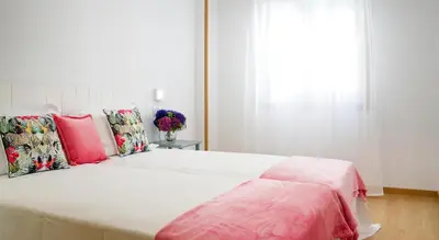 a bedroom with a large white bed with colorful pillows at Duerming Sea View Viveiro in Viveiro