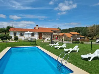 a swimming pool with chairs and a house at Pensión Ribadiso in Arzúa