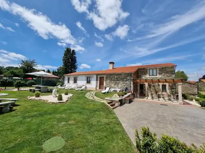 an exterior view of a house with a large yard at Pensión Ribadiso in Arzúa