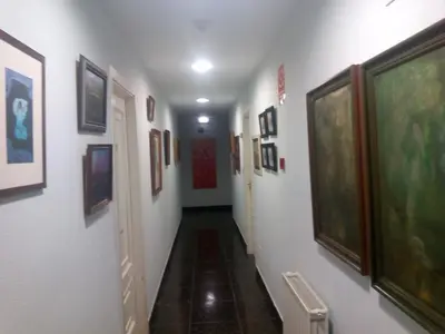 a hallway with paintings and pictures on the walls at Hotel Las Grandas in Vistalegre