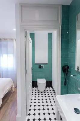 a bathroom with a toilet and a green wall at Casa Amando in Somozas