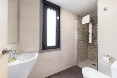 a bathroom with a sink and a toilet and a window at Pension Residencial Victoria in Santa Cruz de Ribadulla