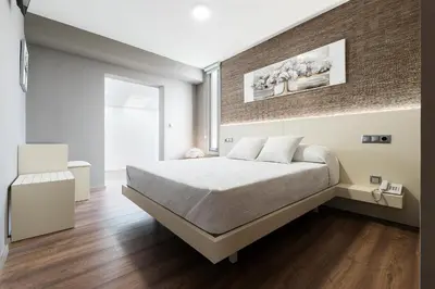 a bedroom with a bed and a brick wall at Pension Residencial Victoria in Santa Cruz de Ribadulla