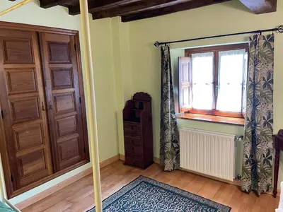 a room with a door and a window and a rug at Hotel y apartamentos rurales L'Anceo in Cibuyo