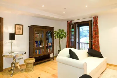 a living room with a white couch and a table at Hotel y apartamentos rurales L'Anceo in Cibuyo