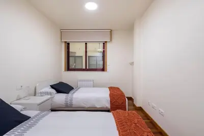 a bedroom with two beds and a window at Apartamento Lua in Milladoiro