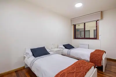 two beds in a room with a window at Apartamento Lua in Milladoiro