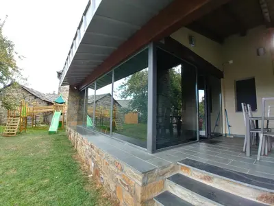 a patio with sliding glass doors on a house at Alojamientos Marel Sanabria in Villarino de Sanabria