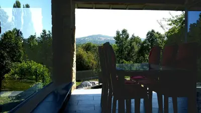 a balcony with a table and chairs looking out a window at Alojamientos Marel Sanabria in Villarino de Sanabria