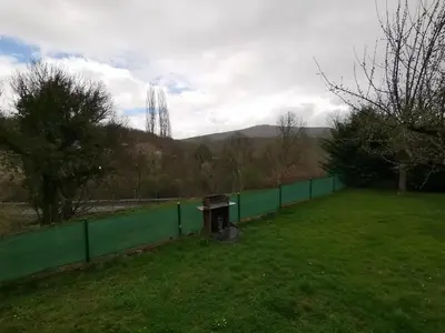 a green fence with a bench in a field at Alojamientos Marel Sanabria in Villarino de Sanabria