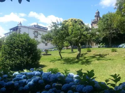 a garden with blue flowers in front of a building at Pazo Vilabade in Vilabade