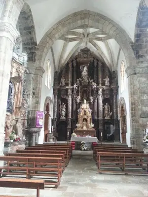 a church with a large altar with wooden benches at Pazo Vilabade in Vilabade