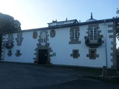 a large white building with windows and a door at Pazo Vilabade in Vilabade
