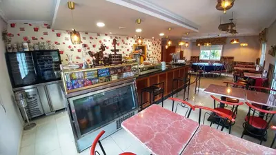 a restaurant with tables and chairs and a bar at Casa Tia Teresa in Salceda