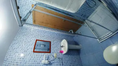 a blue tiled bathroom with a toilet and a red picture at Casa Tia Teresa in Salceda