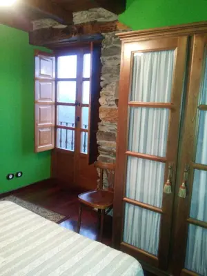 a bedroom with green walls and a stone wall at Casa Colason in El Otero