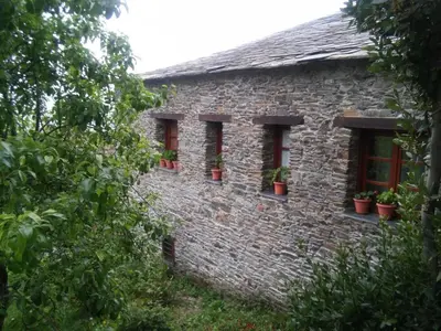 a stone house with three windows with potted plants at Casa Colason in El Otero