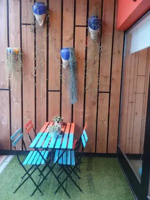a table and chairs with flower baskets on a wall at Albergue Milladoiro in Milladoiro