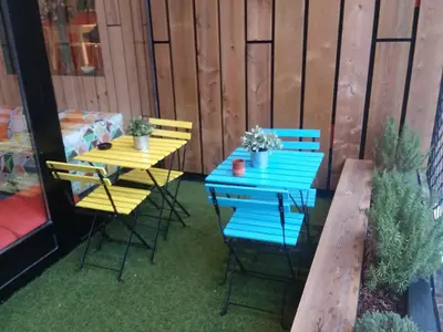 a blue and yellow table and chairs on a patio at Albergue Milladoiro in Milladoiro