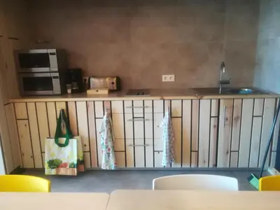 a living room with a counter with a microwave and a table at Albergue Milladoiro in Milladoiro