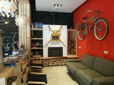 a living room with a couch and a bike on the wall at Albergue Milladoiro in Milladoiro