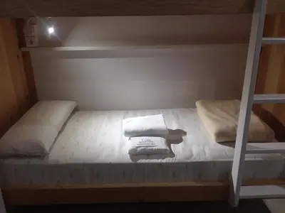a bunk bed with two pillows and towels on it at Albergue Milladoiro in Milladoiro