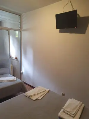 a room with two beds and a television on the wall at A Concha in Lavacolla