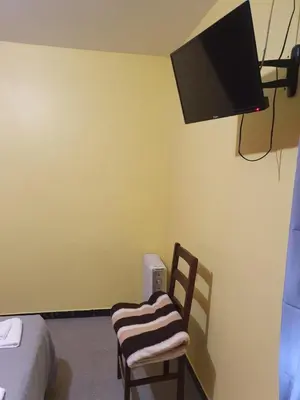 a room with a chair and a tv on the wall at A Concha in Lavacolla